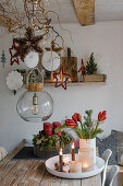 Weihnachtliche Deko mit Adventskranz, Blumenstrauß und aufgehängten Sternen im Esszimmer