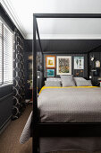 Queen bed with a frame in a bedroom with a black wall