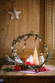 Weihnachtlicher Dekokranz mit Kerzen und Tannenbaum auf Holztisch
