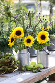 Bouquet of sunflowers and poppy capsules in milk cans