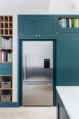 Blue built-in cupboard and stainless steel refrigerator