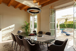 A light-filled dining room with leather chairs overlooking a terrace