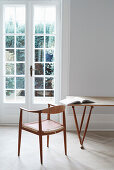 Designerstuhl und Tisch vor Glastür in hellem Raum