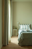 Einzelbett mit mintgrüner Tagesdecke und farblich passendem Betthaupt