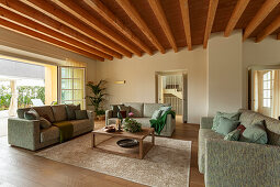 Upholstered sofas in a lounge with a wooden ceiling and terrace access
