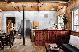 Sitzbereich, rustikale Küche und Essbereich in offenem Wohnraum
