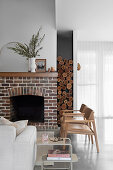 Brick fireplace, leather chairs in front, sofa, and side table in a living room