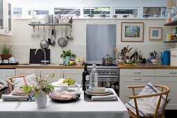 Blick über gedecktem Esstisch auf Küchenzeile