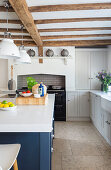 Mittelblock mit blauen Fronten in offener Küche mit Holzbalkendecke