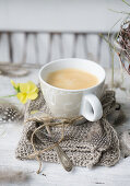 Eine Tasse Kaffee auf Strickserviette auf dem Ostertisch