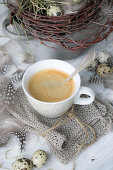 Eine Tasse Kaffee auf Strickserviette auf dem Ostertisch