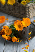 Marigolds (calendula) on a plate and in a vintage metal container