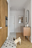 Fitted kitchen with wooden fronts, dog on two different floor coverings