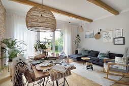 Open living room with dining table, woven pendant light above it