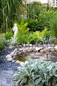 Small pond with pebbles and statue in the garden
