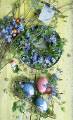Old baking tin with wreath of forget-me-nots and birch twigs, wreath with Easter egg