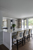 White kitchen counter and bar stools with floral upholstery