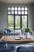 Sofas mit blau-weißem Bezug und Couchtisch aus Holz im Zimmer mit Fenstertüren