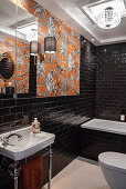 Badezimmer mit schwarzen Wandfliesen und Tapete in Orangetönen