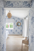 Blick ins helle, lichtdurchflutete Schlafzimmer mit blau-weißer Tapete