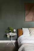 Filigraner Nachttisch neben Bett im Schlafzimmer mit grünen Wänden