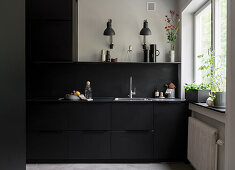 Open-plan kitchen, cupboard and back wall in black