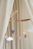 Sand-colored bed canopy with mobile