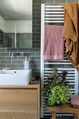 Handtuchtrockner neben Waschtisch im Bad mit grauen Wandfliesen