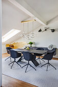 Elegant dining room with dark shell chairs, above a pendant light with glass globes