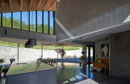 Open kitchen and dining area with a concrete floor in an architect's house with a curved roof