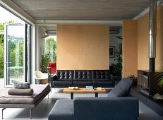 Living room with black leather couch, armchair, and daybed