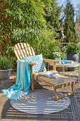 Wooden deckchair with cushions and throw blanket on the patio