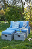 Gemütliche Loungemöbel mit blauen Auflagen auf der Wiese