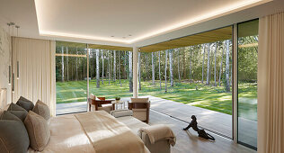Bedroom with floor to ceiling windows and view of the forest