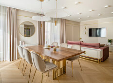 Essbereich, Sofa und Fernseher in elegantem Wohnraum in Pastelltönen
