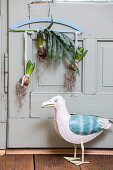 Hyacinth bulbs hanging on a coat hanger, decorative duck in the foreground