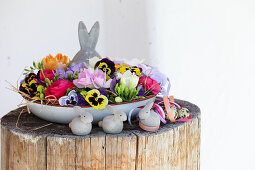 Flower bowl with Easter bunny figurine on tree stump