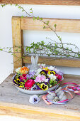 Flower bowl with Easter bunny figurine on wooden bench