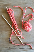 Knitting needle with salmon-coloured wool
