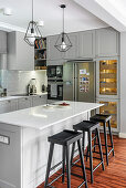 White grey kitchen with kitchen island in open living room