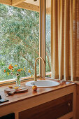 Kleine Küchenzeile mit Spülbecken vor Fenster mit Gartenblick