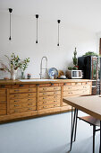 Küche mit Holzarbeitsfläche und Vintage-Schrank, Pendelleuchten
