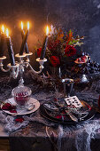 Tischdekoration mit brennenden Kerzen zu Halloween