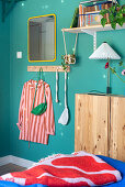 Offenes Regal, darunter schmaler Holzschrank im Schlafzimmer mit blauen Wänden