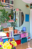 Retro shelves, wall mirror and houseplants in colorful living room