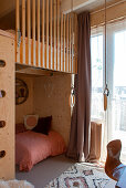 Loft bed made of pine wood with cozy snuggle corner and ring swing in the children's room