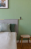 Bett mit Wandbehang als Betthaupt in grünem Schlafzimmer