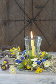 Lantern with candle in a wreath of muscari, primroses (Primula veris), primroses and hay