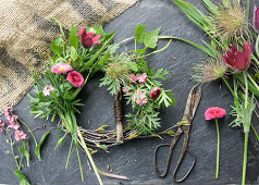 Wreath made of pasque flower (Pulsatilla), forget-me-not, daisies (Bellis) and birch twigs