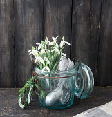 Bouquet of snowdrops and old cutlery in a lidded jar